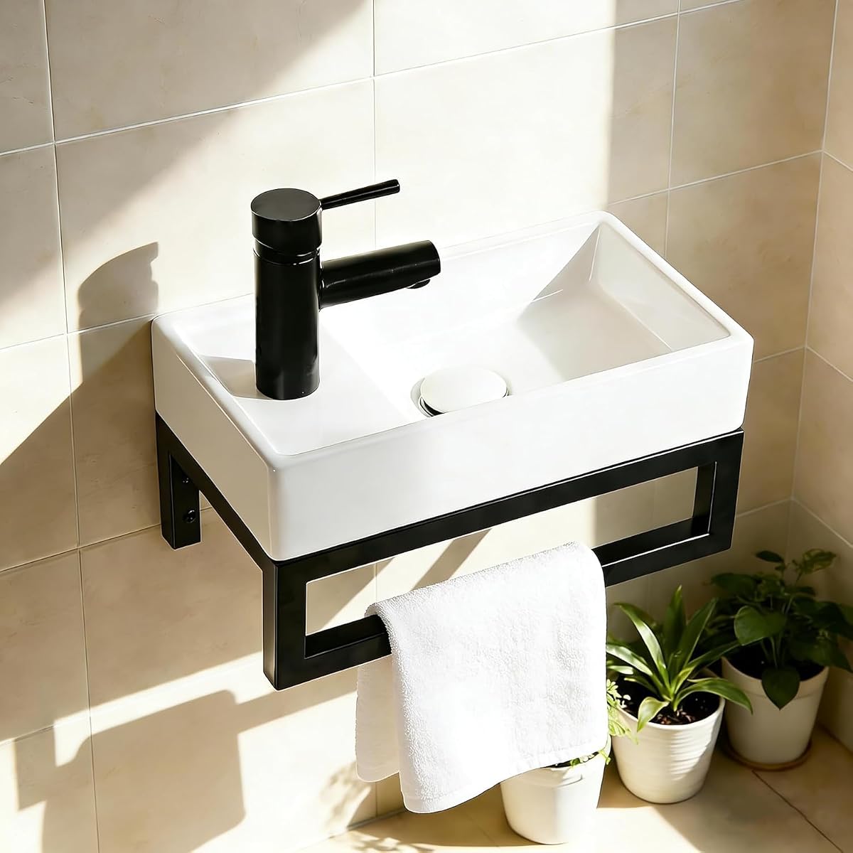 Lave-mains mural en céramique blanche avec structure porte-serviettes noire dans un WC lumineux