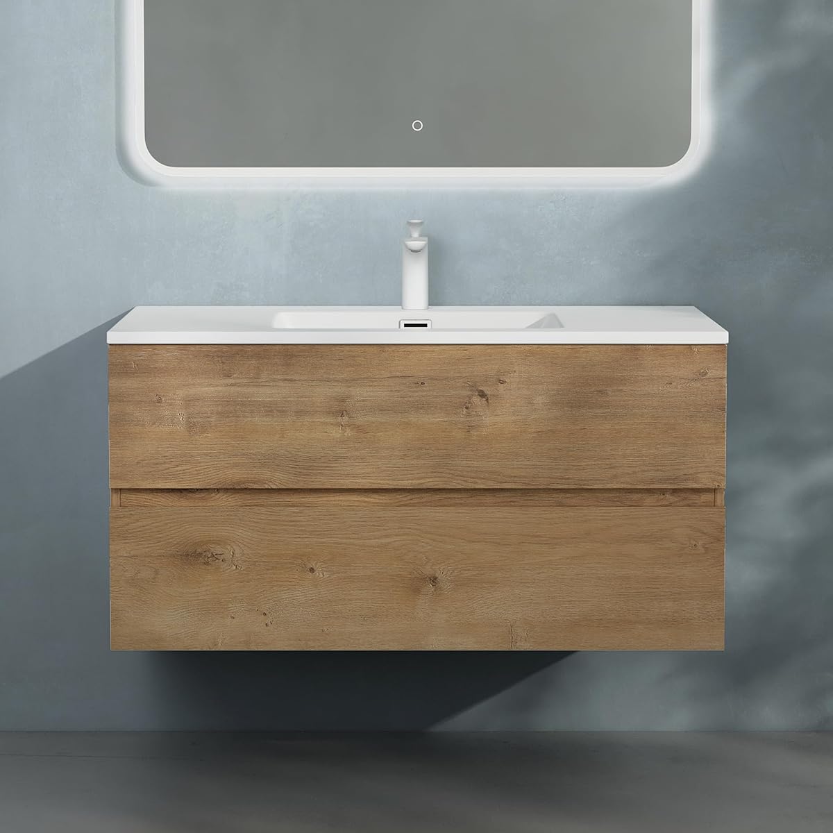 Meuble sous lavabo suspendu effet chêne avec deux tiroirs et vasque blanche en fonte minérale.
