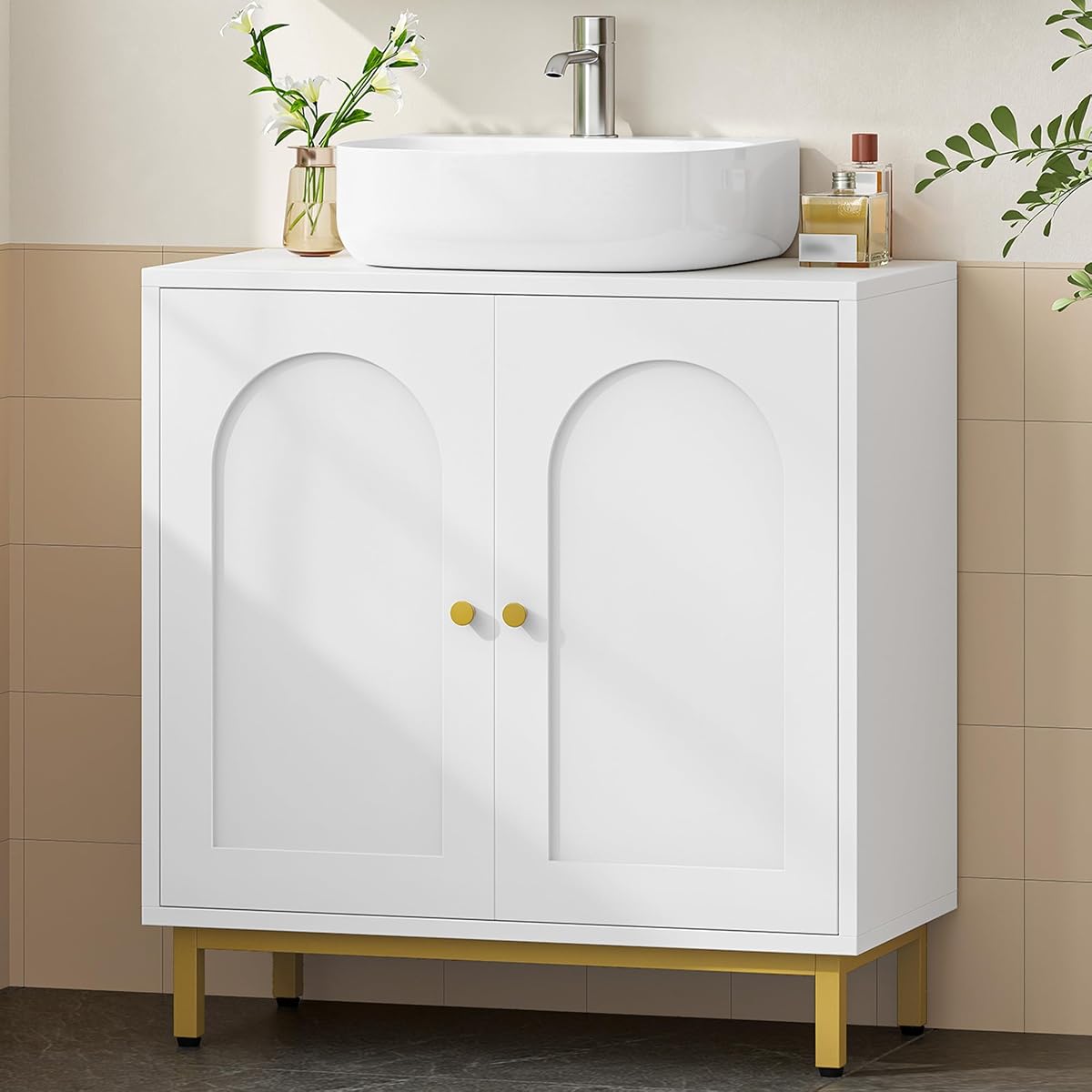 Meuble sous lavabo blanc à portes arquées et pieds dorés dans une salle de bain lumineuse.